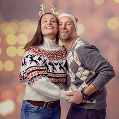 Middle-aged happy couple holding a paper concept mistletoe and looking very loved celebrating for christmas