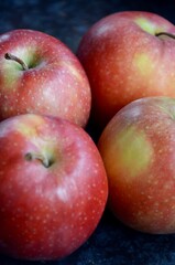 Closeup of organic grown red apples with no perfect peel, black background, advertising for fruits, agriculture, vitamins, nutrition
