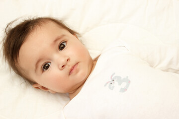 Little cute baby girl on the blanket, indoors