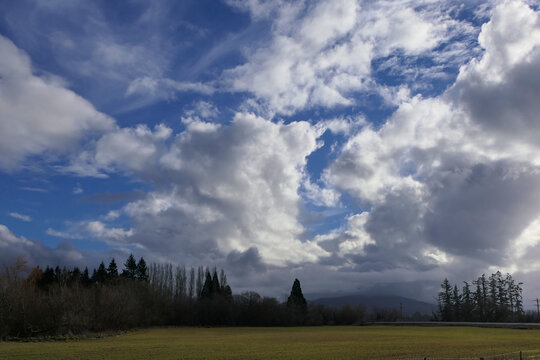 Fulminant sky play with tattered clouds in blue sky over a dreamlike natural landscape