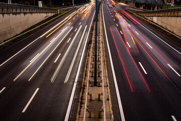 Overhaul with red car light trails on a motorway in night dawn