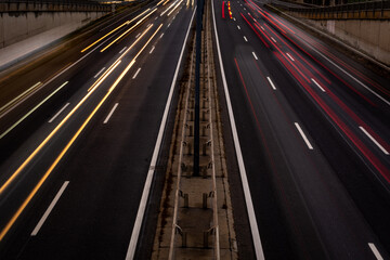 Fototapeta na wymiar Overhaul with red car light trails on a motorway in night dawn
