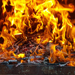 Empty flaming charcoal grill with an open fire, for cooking the product. The fiery background.