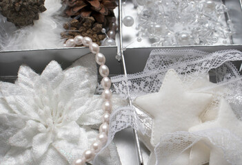 Festive Christmas decorations are white in a close-up box. stars, ribbons, bumps, beads