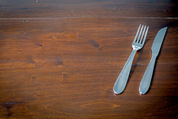 fork and knife on wooden table