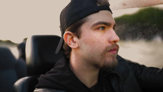 Giovane ragazzo con cappello nero guida una macchina