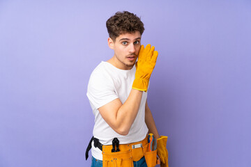 Young electrician man over isolated on purple background whispering something