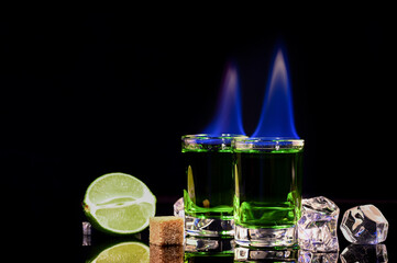 Shots of absinthe and sugar cubes isolated on black background. space for text.