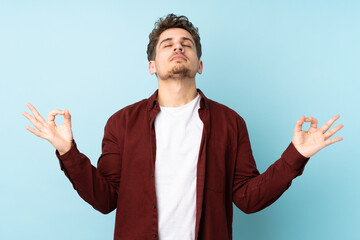 Young caucasian man isolated background in zen pose