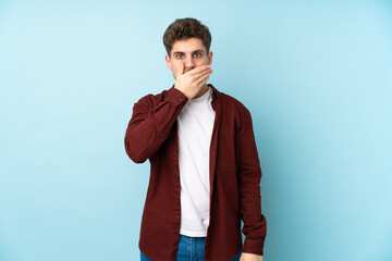 Young caucasian man isolated background covering mouth with hand