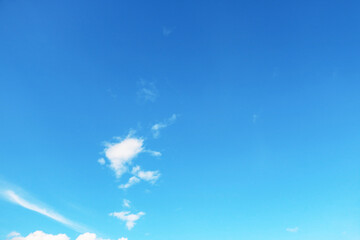 Small, fluffy and lonely clouds in the blue sky with copy space for texture background
