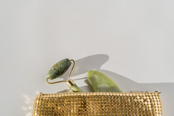 Face quartz roller for anti-aging facial massage, chinese guasha beauty tool, golden bag © troyanphoto