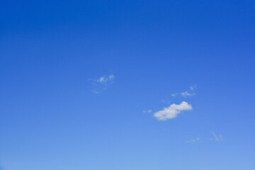 Small, fluffy and lonely clouds in the blue sky.