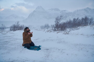 Fototapeta na wymiar Muslim traveler praying in cold snowy winter day