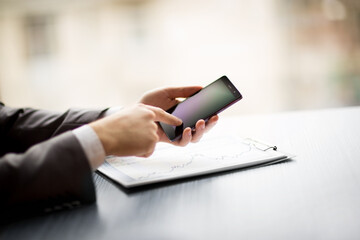 businessman using his smartphone to work with financial data.