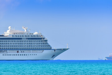 Cruise ship and sideship forward, large luxury white cruise ship liner on blue sea water go from...