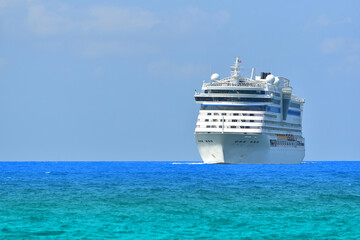 Front view of Cruise ship, large luxury white cruise ship liner on blue sea water and cloudy sky background.