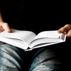 A cozy concept. A man in blue jeans holds a mock white clean book