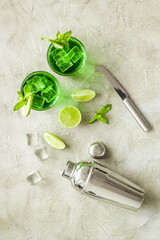 Green Mojito cocktail with bar utensils and ingredients. Top view
