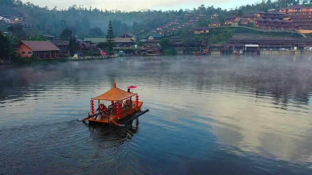 Asian woman wearing chinese traditional dress on a boat at Ban Rak Thai village, Mae hong son province.