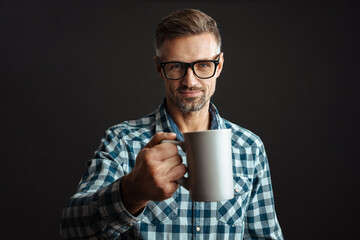Man holding cup of coffee isolated over grey wall background