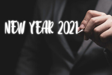 Welcome merry Christmas and happy new year in 2021, Businessman hand writing new year 2021 wording.