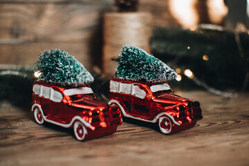 Vintage retro car with christmas tree on the roof. Scandinavian hygge styled Christmas composition. Fir tree, vintage Christmas tree toys. Winter cozy vintage flat lay. New Year holidays. 