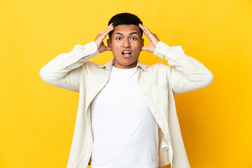 Young Ecuadorian man isolated on yellow background with surprise expression