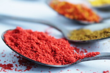 ingredients spices chili peppers and curry in a spoons