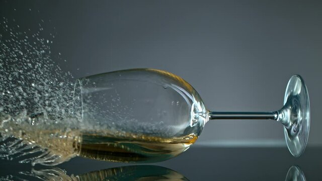 Breaking Glass with White Wine on Grey Background at 1000 fps.