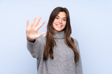 Teenager Brazilian girl over isolated blue background counting five with fingers