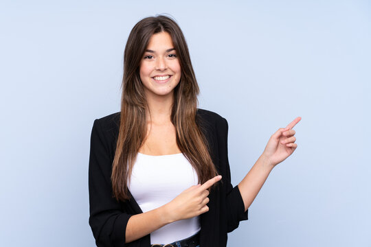 Young Brazilian business woman over isolated blue background pointing finger to the side