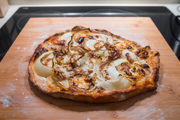 Delicious pizza with goat cheese, honey, nuts, onions and cream. Perfect italian homemade pizza.