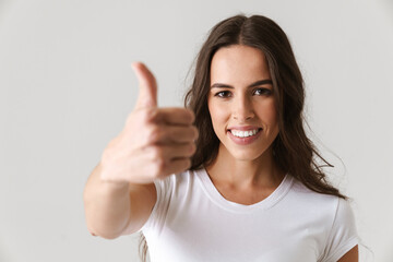 Happy beautiful girl smiling and showing thumb up at camera