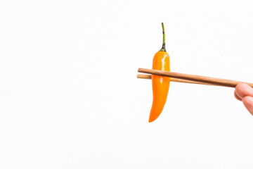 Yellow chilli with chopsticks isolate on white background, spicy food, fresh chilli