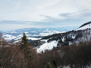 Beautiful natural landscape with mountains and bare trees covered with snow..Ski resort in winter season, Active recreation in the mountains. Isolation concept during quarantine.