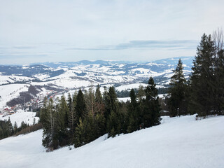 Obraz premium Beautiful natural landscape with mountains and bare trees covered with snow..Ski resort in winter season, Active recreation in the mountains. Isolation concept during quarantine.