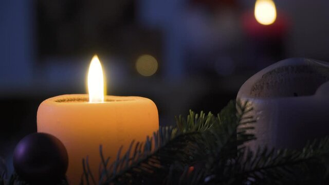 Single candle burning on Christmas decoration in a living room, 4k