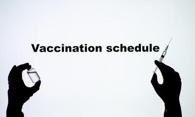 Backlit single shot image of Vaccination schedules with a hand holding an vaccine. © Олександр Луценко