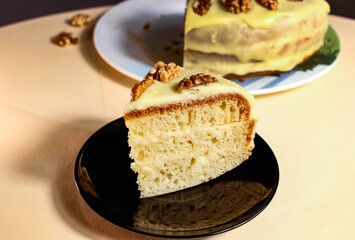 Cut off piece of cake with nuts on a black saucer.
