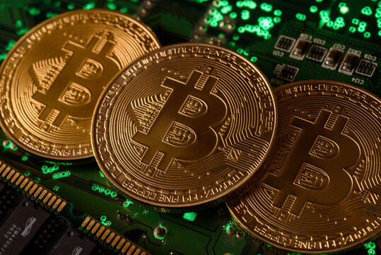 In this photo illustration, Bitcoin cryptocurrency commemorative coins on circuit board.