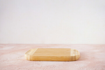 Wooden cutting board on a beige background with place for text.