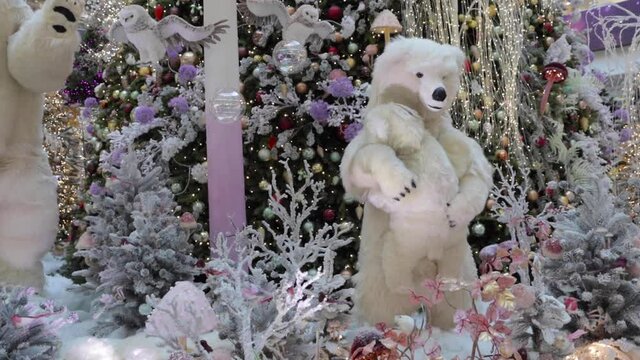 A polar she-bear holding a bear-cub in her arms by the Christmas tree. Dana shopping center - Minsk city, Belarus December 8, 2020.