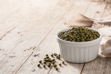 Green soy beans in white bowl on wooden table. Copy space	