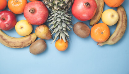 Pineapple, banana, pomegranate on a blue background.