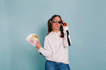 Trendy european woman with funny emotions posing with funny emotions posing with money fan and...