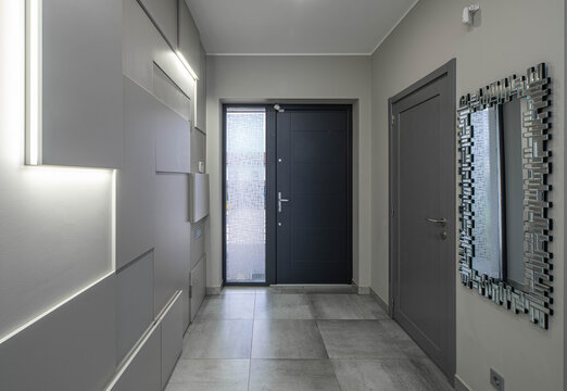 Modern interior of entrance hall in luxury apartment. Grey tones. Hi-tech design of wall.