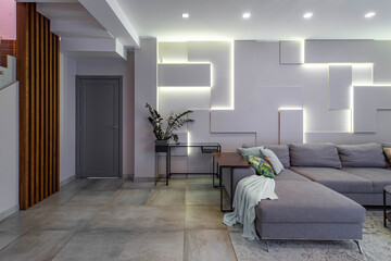 Contemporary interior of luxury studio flat. Modern home design. Huge cozy sofa. Green plant....