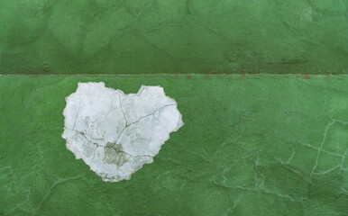 green paint on a wall and white broken heart shape symbol 