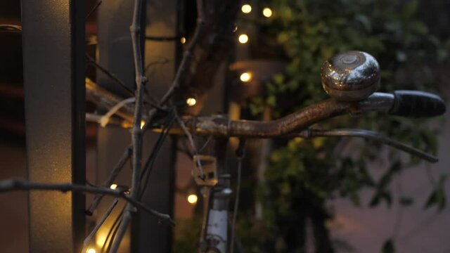 Rusty old bicycle with christmas lights as decoration in front of restaurant